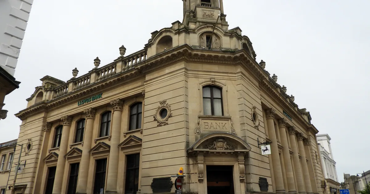 The Grade II-listed Lloyds Bank branch on the High Street in Cheltenham, a classical stone facade at a street corner.