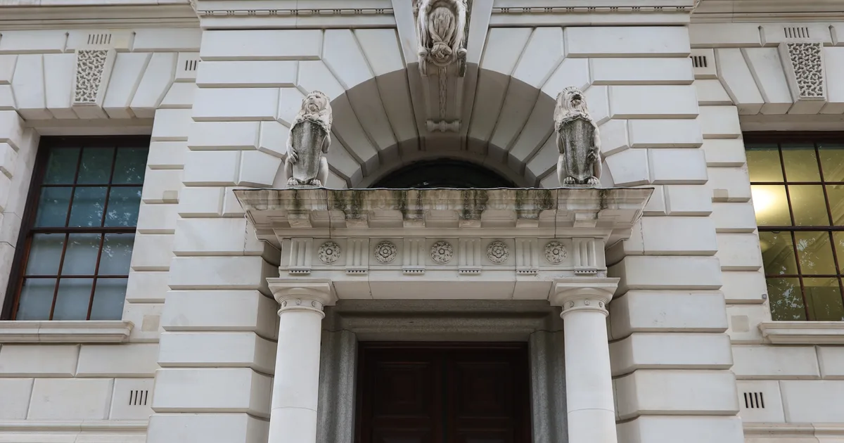 The entrance of HM Treasury at 1 Horse Guards Road, London, showing carved stone lions above the doorway.