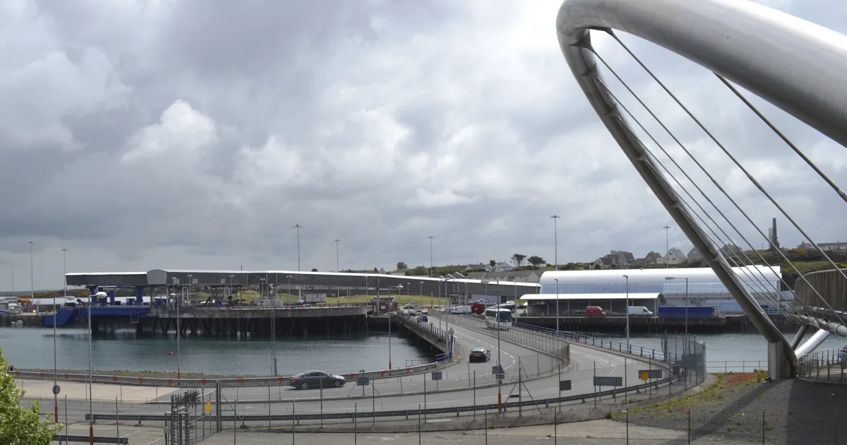 The approach road to the ferry terminal at the Port of Holyhead, Anglesey, with the steel arch of the Celtic Gateway footbridge in the foreground.