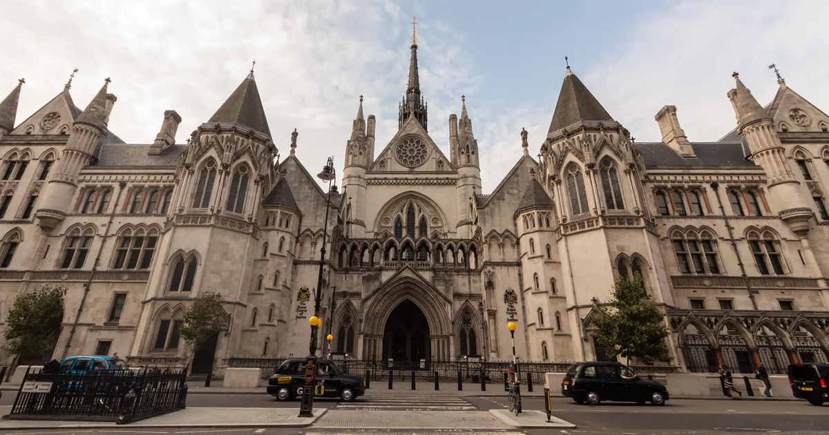The Gothic Revival facade of the Royal Courts of Justice on the Strand, London, with its central spire and arched entrance.