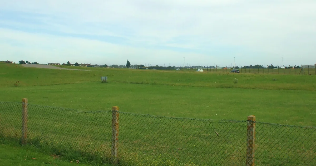 Grass airfield and perimeter fencing at the former RAF Manston, Kent, the site of the Home Office's migrant processing centre.