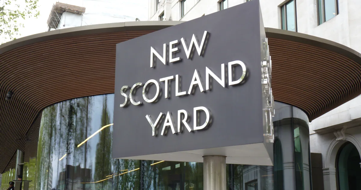 The rotating triangular New Scotland Yard sign outside the Metropolitan Police's headquarters in London.