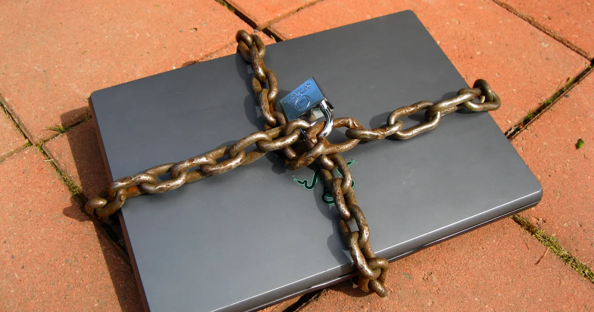 A padlock resting on a laptop keyboard, symbolising restricted access to a computer.