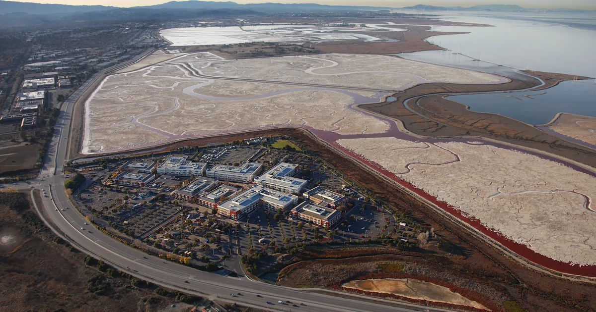 Aerial view of a Meta office campus beside San Francisco Bay salt ponds, Menlo Park, California.