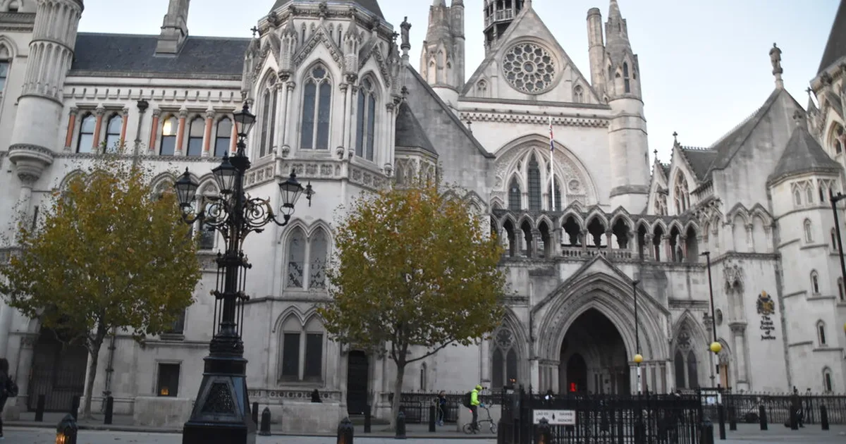 The Gothic facade of the Royal Courts of Justice on the Strand, London, with its central rose window and arched entrance.