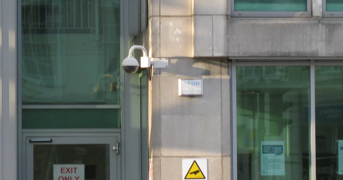 A dome CCTV camera mounted on the corner of an office building in London.