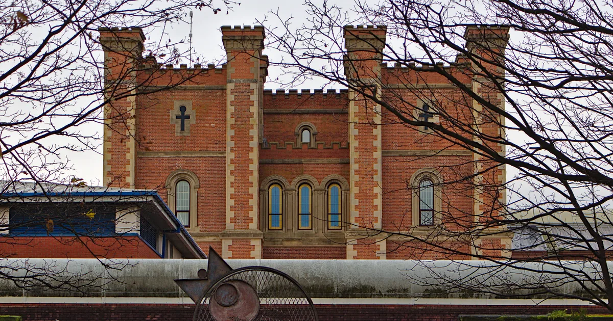The Victorian gatehouse of HMP Liverpool (Walton), a red-brick building with a clock tower behind a high perimeter wall.