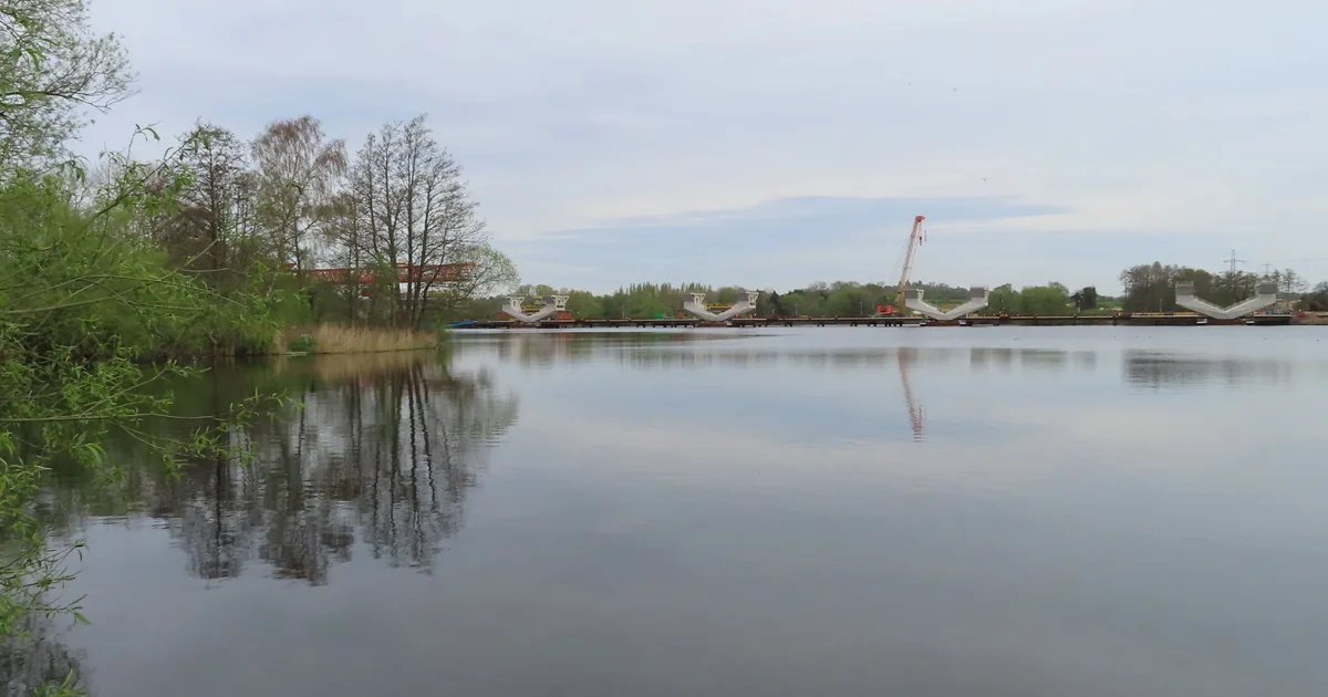 Concrete piers for an HS2 railway viaduct rising from Harefield Lake in Hillingdon, under construction.