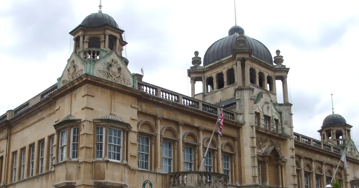 The ornate stone towers and domed roofline of Redbridge Town Hall in Ilford, photographed from street level against a cloudy sky.