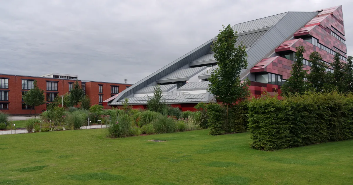 Newark Hall and International House, a modern student accommodation building on the University of Nottingham's Jubilee Campus, with lawn and trees in front.