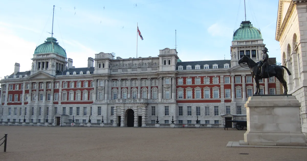 The Old Admiralty Building on Whitehall, London, a stone building with two green copper domes, seen across Horse Guards Parade.